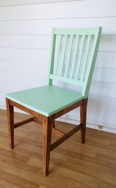 a green wooden chair sitting on top of a hard wood floor