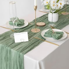 the table is set with green napkins and place settings