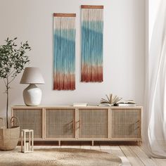 two wall hangings in the corner of a room with a rug on the floor