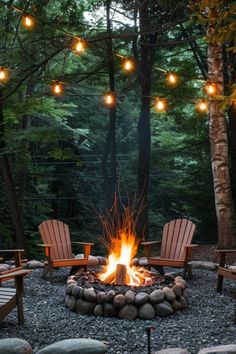 an outdoor fire pit with chairs around it and lights strung from the trees in the background