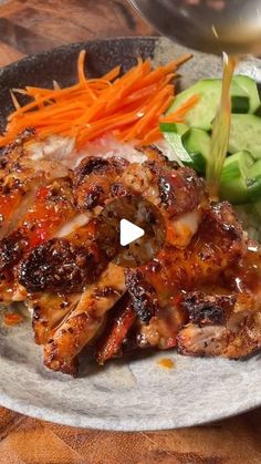 a plate topped with meat and vegetables on top of a wooden table