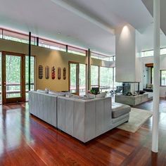 a living room with wood floors and large windows