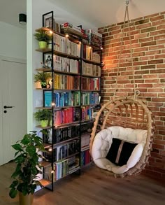 a living room with a hanging chair and bookshelf full of books on shelves