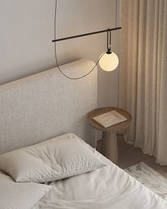 a bed with white sheets and pillows in a bedroom next to a lamp hanging over the headboard