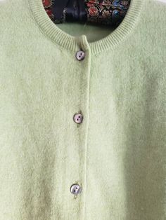 This is a vintage cardigan sweater. It is green, long sleeved and has Mother of Pearl buttons. I do not know its size as there is no label. Please refer to the measurements for a proper fit. I think this sweater is possibly lambswool or angora. I am not sure due to the missing label. Please note, there are 2 or 3 spots that are a bit dark. I dont think these are stains, just little dark marks in the fibers. They are evident in the 4th and 5th pictures. Please feel free to ask to see an image. Th Green Button-up Winter Cardigan, Green Button-up Winter Sweater, Green Buttoned Top For Winter, Green Winter Top With Buttons, Green Buttoned Cardigan For Layering, Green Buttoned Sweater For Fall, Green Fall Sweater With Button Closure, Green Buttoned Sweater For Layering, Green Button Closure Sweater For Fall