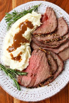 roast beef with mashed potatoes and gravy served on a white platter