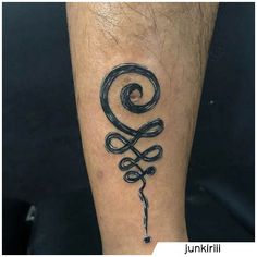 a tattoo on the leg of a man with a swirly symbol in black ink