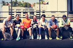 a group of people sitting next to each other holding tennis balls