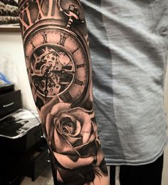 a man's arm with a clock and rose tattoo on it