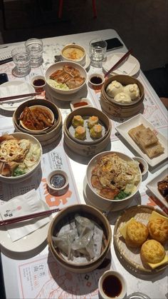 a table topped with bowls filled with different types of food next to chopsticks