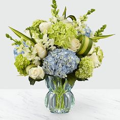 a vase filled with green and white flowers