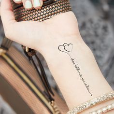 a woman's arm with a small tattoo on it