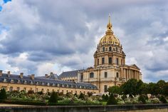 a large building with a golden dome on it's top surrounded by greenery