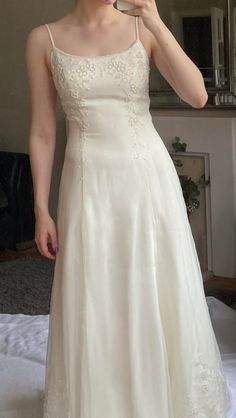 a woman in a white dress brushing her teeth