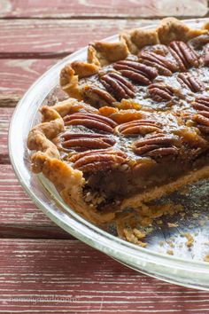 a pie with pecans on top sitting on a table