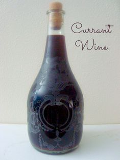 a wine bottle sitting on top of a table next to a white wall with the words currant wine written in it