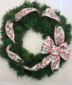 a green wreath with red and white bows