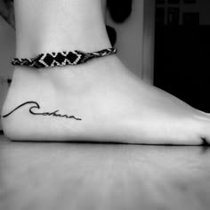 a black and white photo of a woman's foot with a tattoo on it