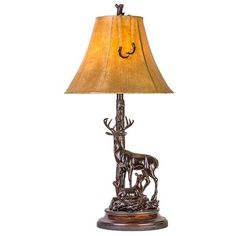 a lamp that is on top of a wooden base with a deer and antelope