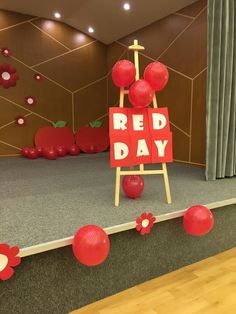 a red day sign sitting on top of a wooden easel in front of a stage