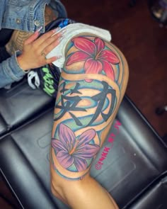 a woman's leg with flowers on it and the word love written in cursive writing