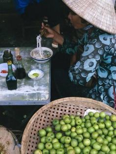 two women sitting at a table with bowls of food and bottles of wine in front of them