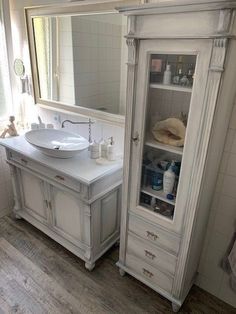 a bathroom with a sink, cabinet and mirror