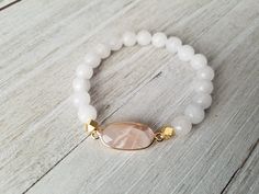 Gorgeous white stack features: -milky white with gold bead and spacers -matte white jade with matte gold hematite and gold spacers -white moonstone paired with a pink moonstone pendant. Pick one or all 3 of them. Choose your bracelet choice and your size from drop box. All your items will be packaged and shipped in a cotton filled kraft box. Adjustable White Crystal Bracelet With Gemstone Beads, Adjustable White Beaded Bracelets With Gemstones, Adjustable White Pearl Bracelet With Gemstone Beads, Adjustable White Gemstone Beaded Bracelets, White Spiritual Stretch Bracelet With Gemstone Beads, Spiritual White Gemstone Beads Stretch Bracelet, White Stretch Bracelet With Faceted Beads For Gift, White Pearl Bracelet With Gemstone Beads For Spiritual Wear, White Spiritual Bracelets With Faceted Beads