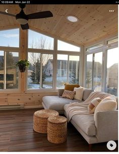 a living room filled with furniture and windows covered in wooden planks on top of a hard wood floor