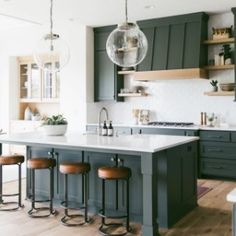 a large kitchen with an island and bar stools