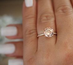 a woman's hand with a ring on it and a diamond in the middle