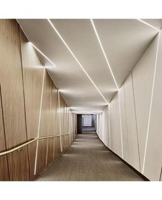 a long hallway with white walls and wood paneling