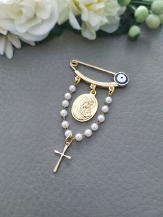 a rosary with a cross and an eye on it next to some white flower petals