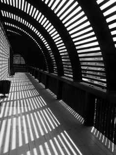 the sun shines through an arched ceiling in a building with wooden slats on it