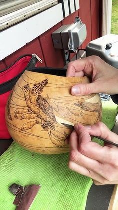 two hands are working on a wooden object