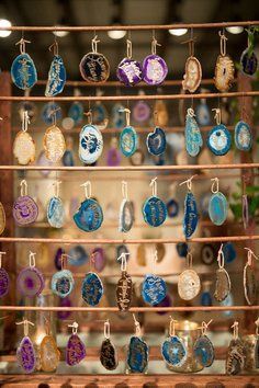 many different colored glass ornaments are hanging on a rack