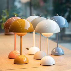 several different colored lamps sitting on top of a wooden table