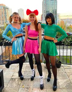 three young women dressed in costumes posing for the camera