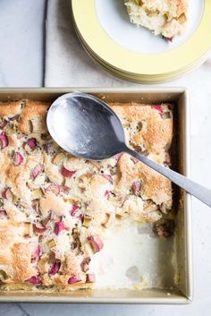 a close up of a pan of food with a spoon in it and another plate on the side