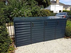 a car parked in front of a metal fence with two doors on it's sides