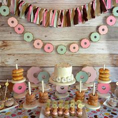 a table topped with cakes and cupcakes on top of a table covered in confetti