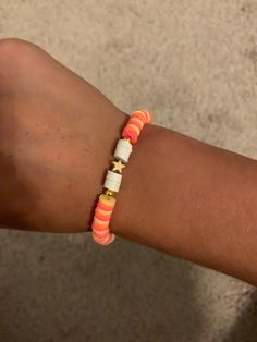 a person wearing an orange and white bracelet