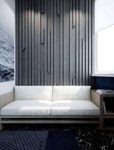 a white couch sitting in front of a wall with wooden paneling on it's sides