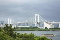 a boat is on the water in front of a bridge