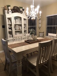 a dining room table with chairs and a china cabinet in the backround area