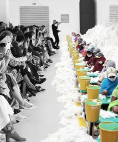 a group of people sitting next to each other in front of a pile of snow