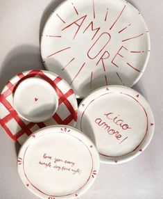 three plates with writing on them are sitting next to each other and one has a red checkered ribbon