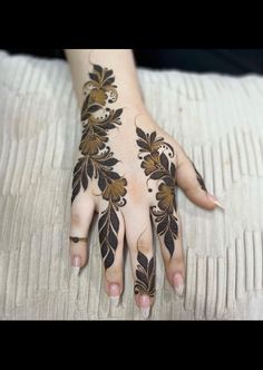 a woman's hand with hennap on it and flowers painted on the palm