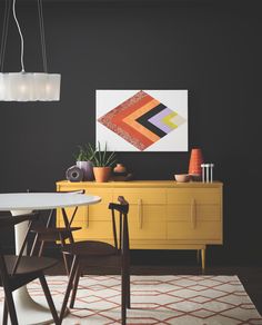 a dining room with black walls and yellow furniture