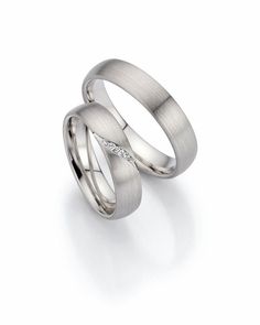 two white gold wedding bands with diamonds on each side, set in 18k white gold